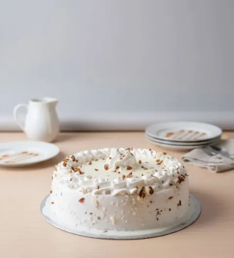 A white three milk cake with swirls of cream